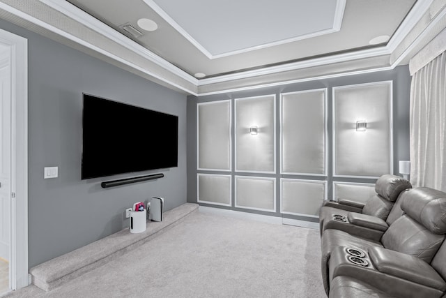 carpeted cinema with a raised ceiling and crown molding