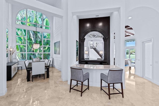 dining area with a towering ceiling and a chandelier