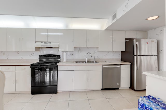 kitchen with appliances with stainless steel finishes, sink, light tile patterned floors, and white cabinets