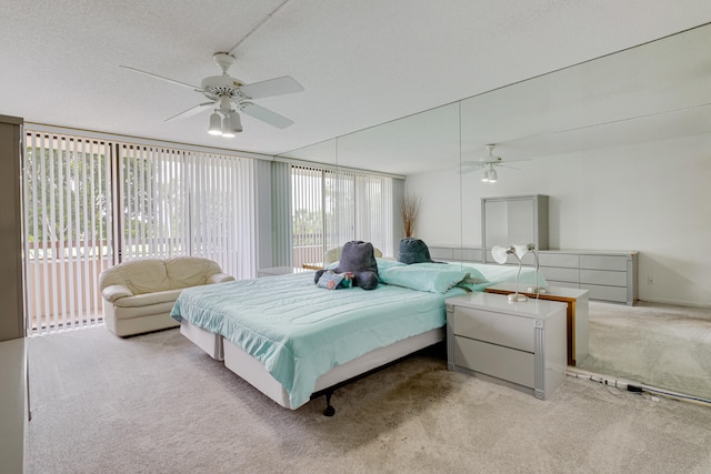 carpeted bedroom with ceiling fan, multiple windows, and a textured ceiling