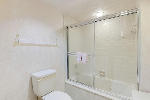 bathroom featuring shower / bath combination with glass door and toilet