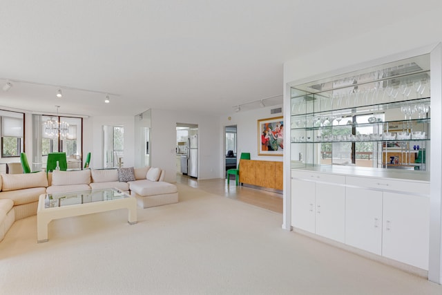 living room with a notable chandelier, plenty of natural light, and track lighting