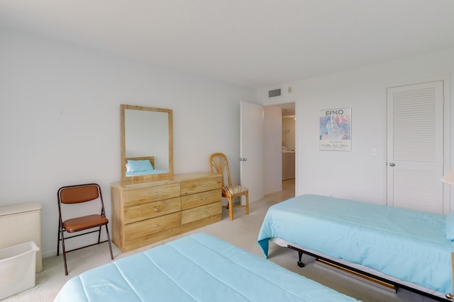 bedroom featuring light carpet and a closet