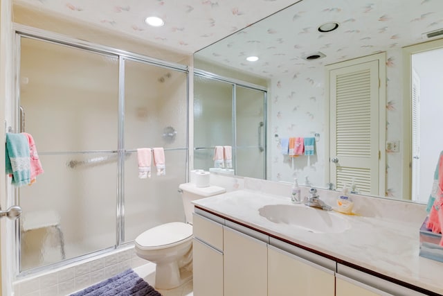 bathroom with tile patterned floors, an enclosed shower, vanity, and toilet