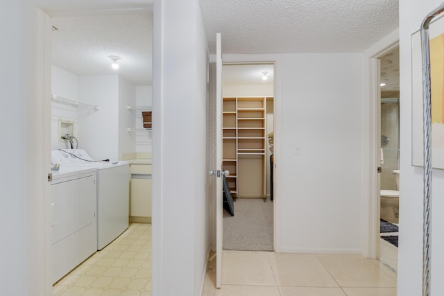 washroom with a textured ceiling and independent washer and dryer