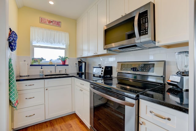 kitchen with white cabinetry, sink, light hardwood / wood-style flooring, and stainless steel appliances