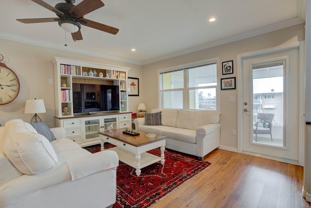 living room featuring crown molding, ceiling fan, and light hardwood / wood-style flooring