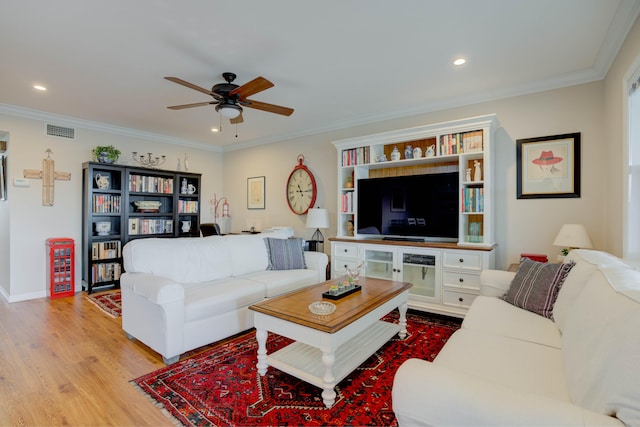 living room featuring ceiling fan, light wood-type flooring, and crown molding