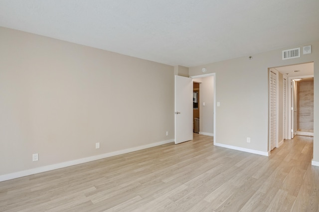 empty room with light hardwood / wood-style flooring