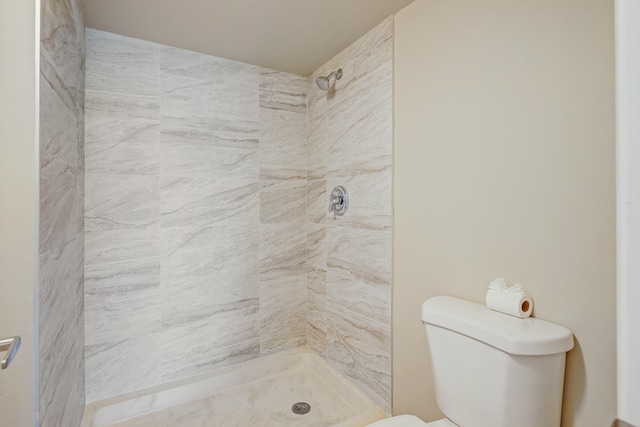 bathroom with tiled shower and toilet