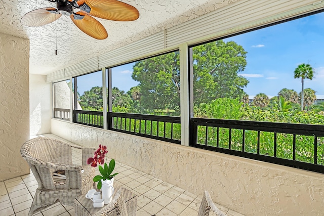 unfurnished sunroom featuring ceiling fan