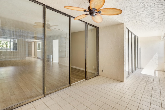 spare room with light tile patterned floors, a textured ceiling, and ceiling fan