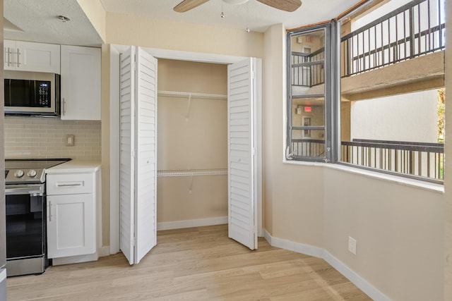 interior space featuring a textured ceiling, light hardwood / wood-style floors, ceiling fan, and a closet