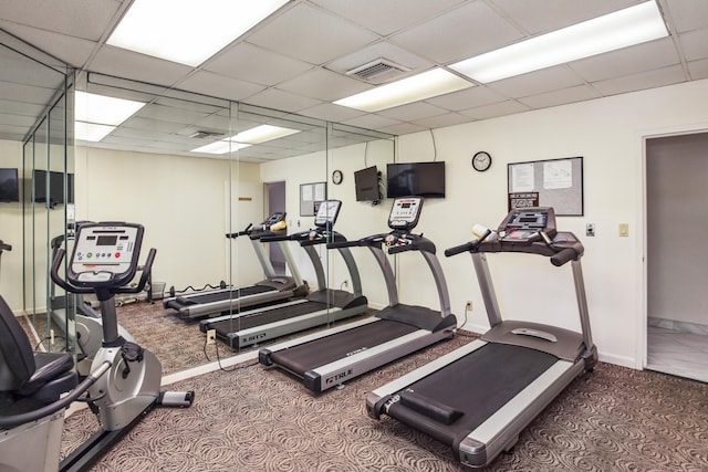 gym with carpet floors and a paneled ceiling