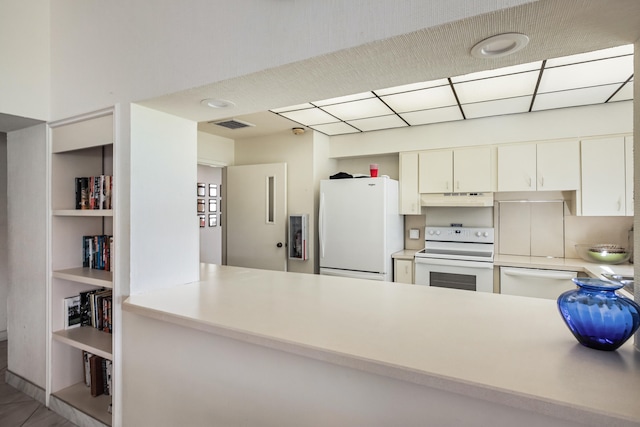 kitchen featuring white appliances, kitchen peninsula, and white cabinetry