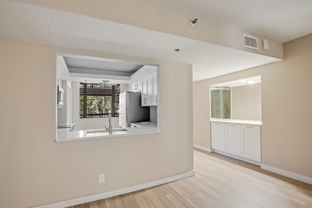 kitchen featuring light wood-type flooring, white cabinetry, stainless steel appliances, and sink