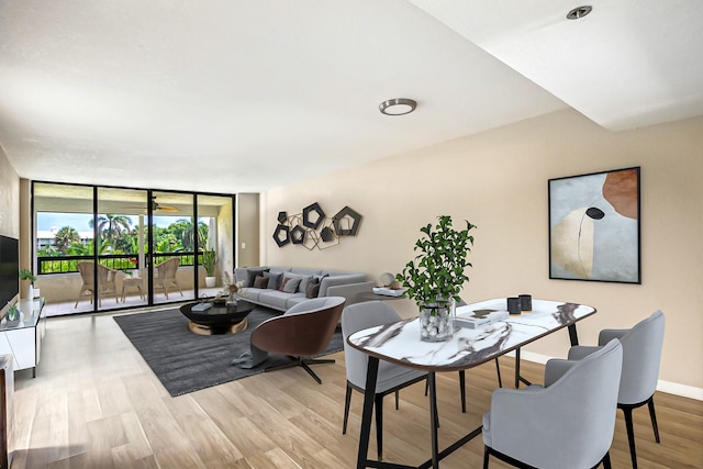 dining area with expansive windows and light wood-type flooring