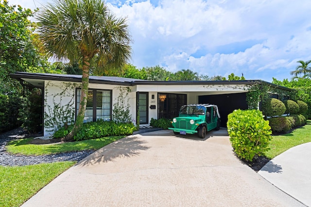 ranch-style house featuring a front lawn and a carport