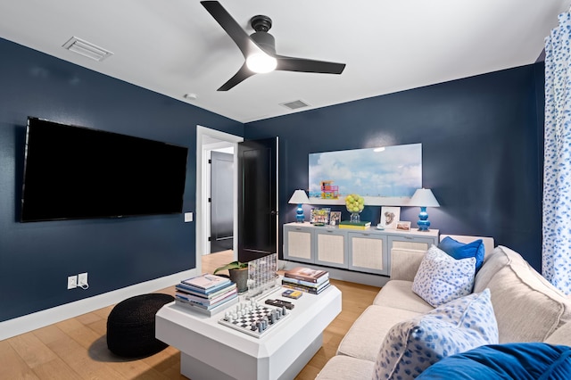 living room with light hardwood / wood-style flooring and ceiling fan