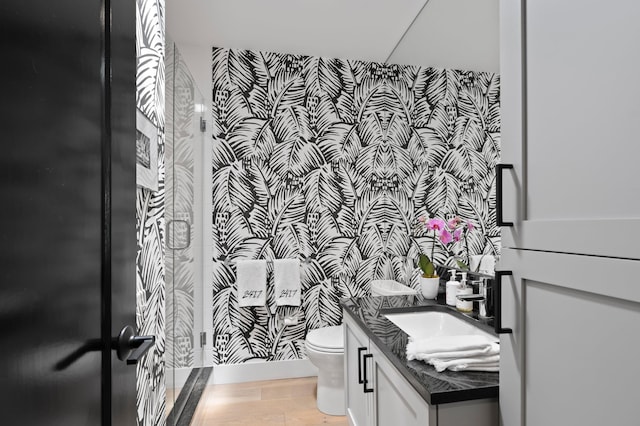 bathroom featuring vanity, hardwood / wood-style floors, toilet, and an enclosed shower