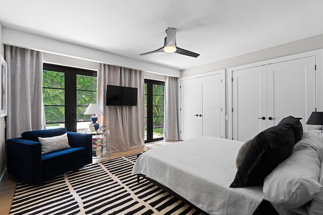 bedroom with multiple windows, ceiling fan, french doors, and hardwood / wood-style flooring