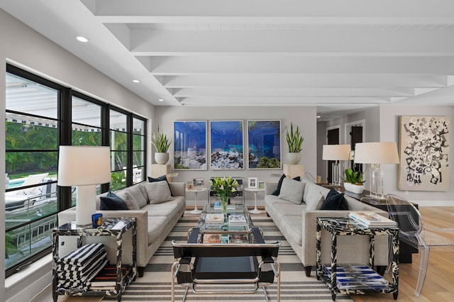 living room featuring beamed ceiling and light hardwood / wood-style flooring