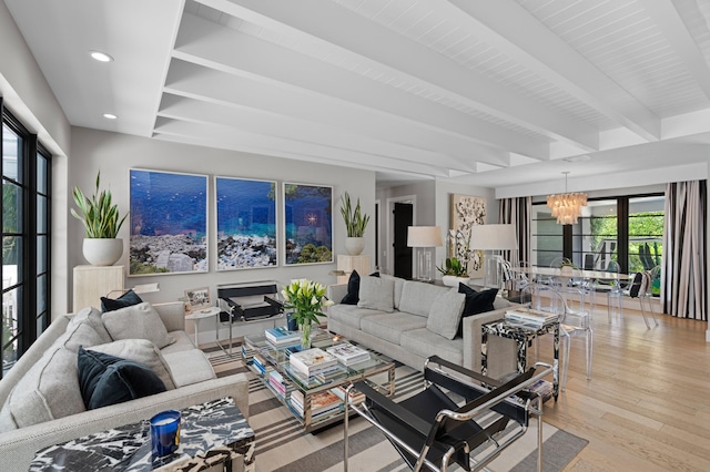 living room featuring a notable chandelier, light wood-type flooring, and beam ceiling