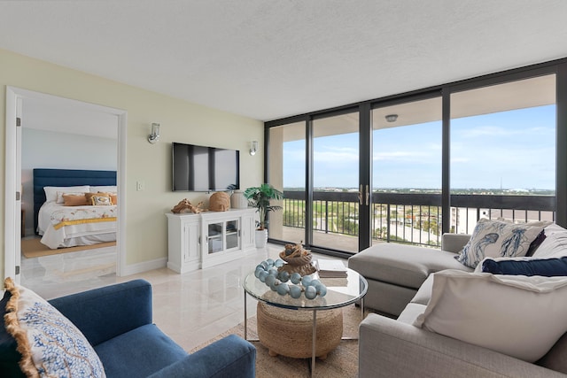 living room featuring a textured ceiling, light tile patterned flooring, and floor to ceiling windows