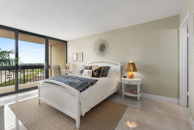 bedroom featuring floor to ceiling windows and access to exterior