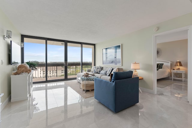 living room with a wall of windows, a healthy amount of sunlight, and a textured ceiling