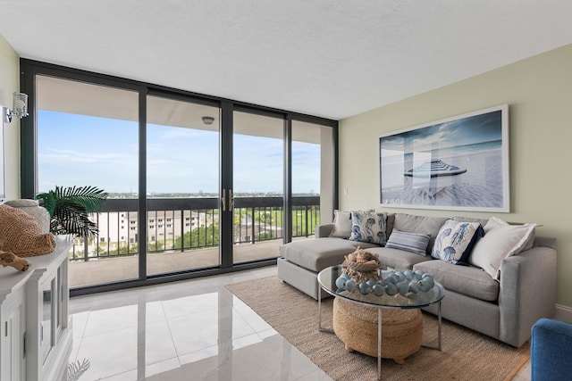 living room with a textured ceiling, floor to ceiling windows, and light tile patterned floors