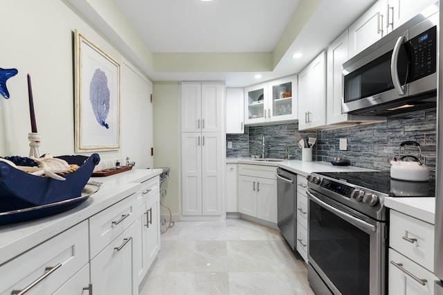 kitchen with white cabinets, appliances with stainless steel finishes, sink, and tasteful backsplash