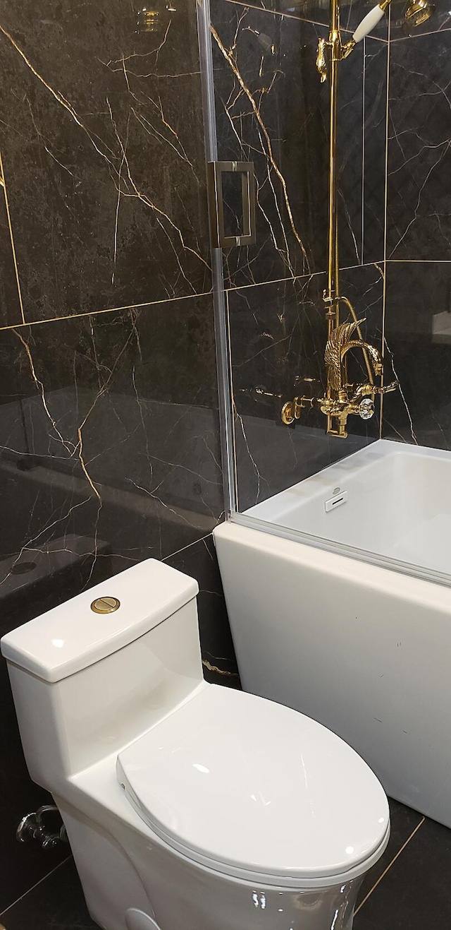 bathroom featuring tile walls and toilet