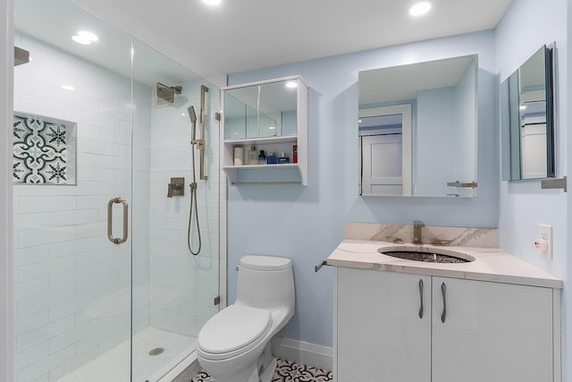 bathroom with vanity, toilet, and a shower with shower door