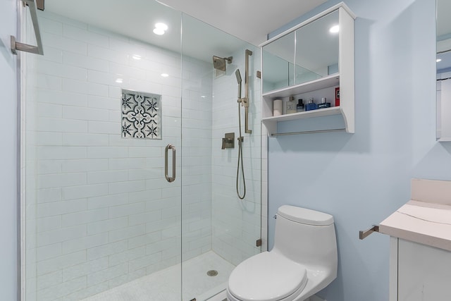 bathroom with a shower with door, vanity, and toilet