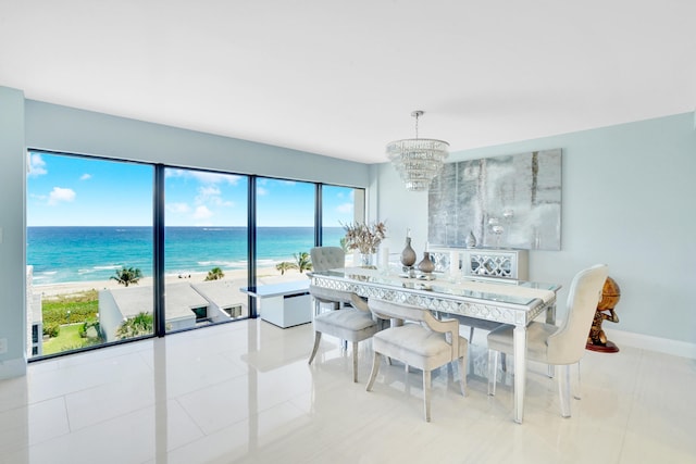 tiled dining space featuring a beach view, a water view, and an inviting chandelier