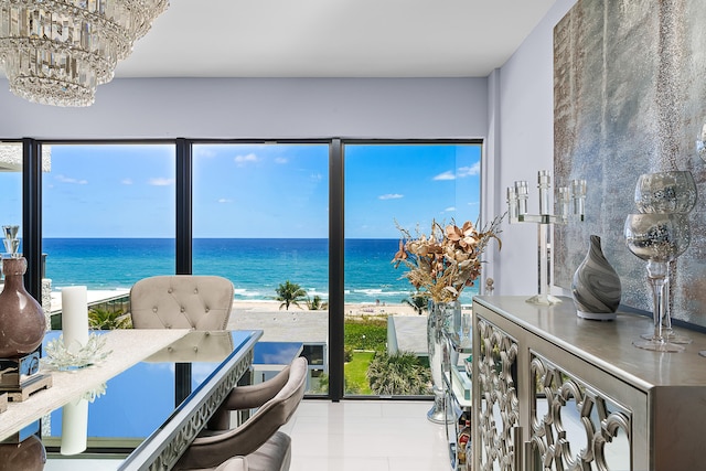 interior space featuring a beach view, a water view, and an inviting chandelier