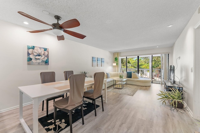 dining room featuring a textured ceiling, light wood-type flooring, and ceiling fan