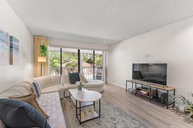 living room with light wood-type flooring and a textured ceiling