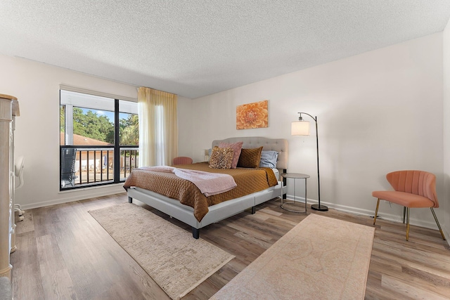 bedroom with light wood-type flooring and a textured ceiling