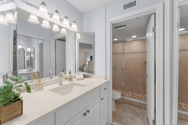 bathroom featuring vanity, a shower with shower door, toilet, and tile patterned flooring