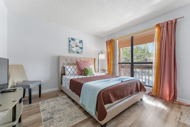 bedroom with a textured ceiling and light hardwood / wood-style flooring