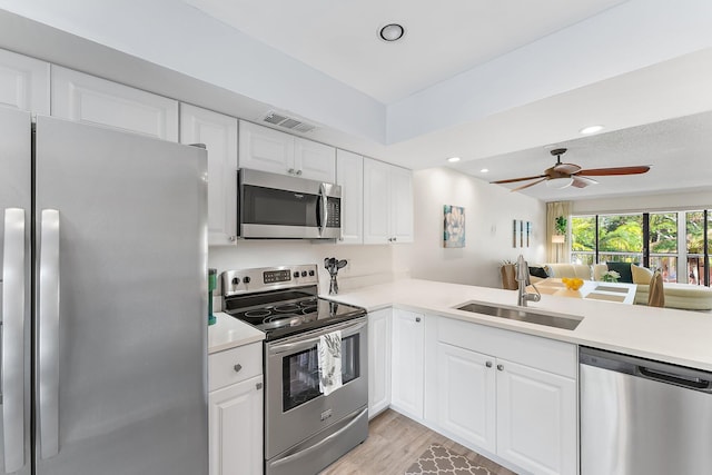 kitchen with light hardwood / wood-style floors, stainless steel appliances, sink, and white cabinetry