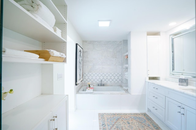 bathroom featuring vanity, tiled tub, and tile patterned flooring