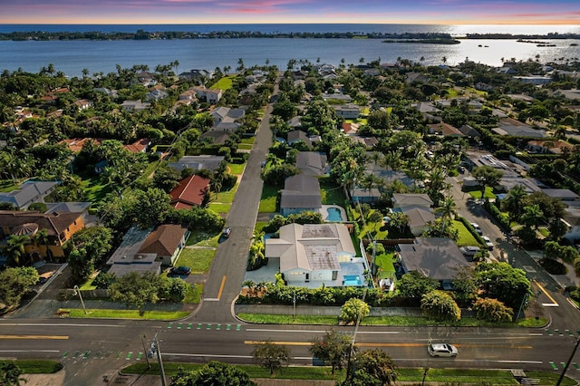 aerial view at dusk featuring a water view