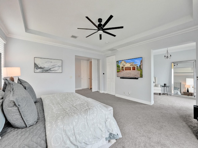 carpeted bedroom with ornamental molding, a tray ceiling, and ceiling fan