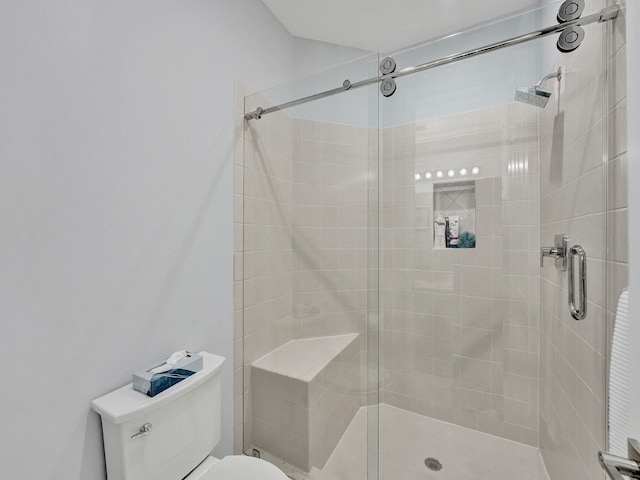 bathroom with a shower with door and toilet