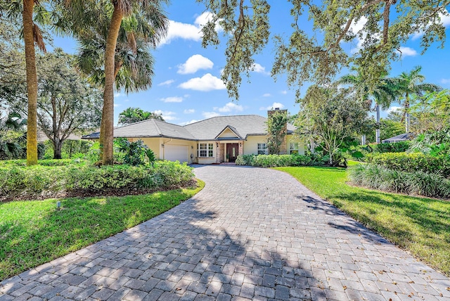 single story home featuring a front yard and a garage