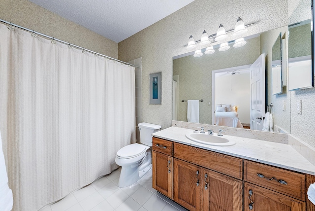 bathroom featuring a textured ceiling, toilet, vanity, and tile patterned flooring