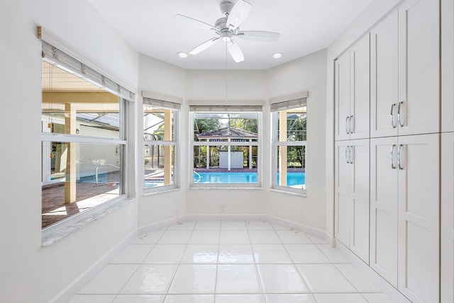 unfurnished sunroom with ceiling fan